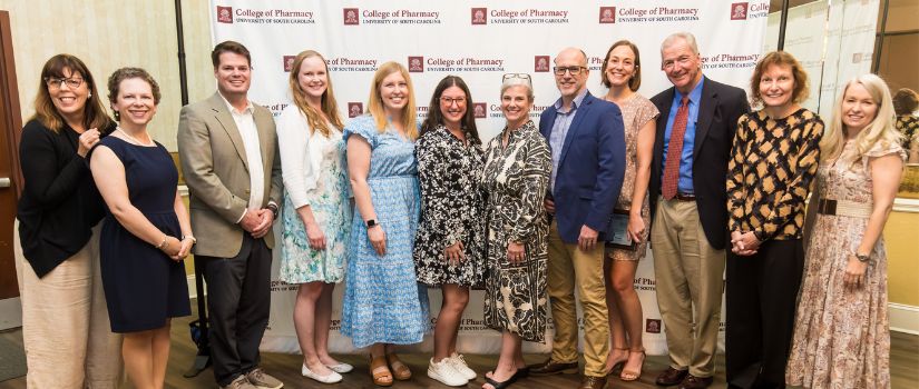 Group of preceptors pose in front of backdrop