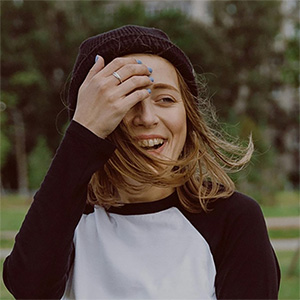 A young girl outside laughing at a joke