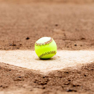 Softball on a home plate in a baseball field 