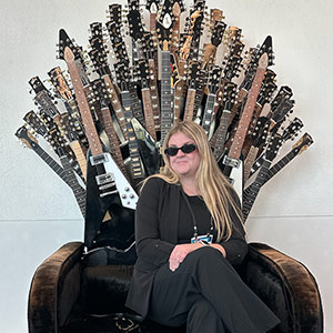 Catherine Pruitt in chair with guitars
